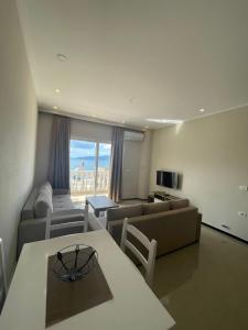 een woonkamer met een bank en een tafel bij Seaside Apartmens Sarande in Sarandë