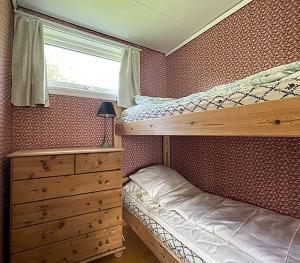 a bedroom with two bunk beds and a dresser and a window at Selje Camping - Hytte Nr 4 in Selje