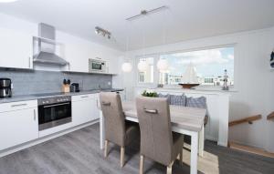 een witte keuken met een houten tafel en stoelen bij Bente in Olpenitz