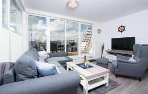 een woonkamer met een bank, stoelen en een televisie bij Bente in Olpenitz