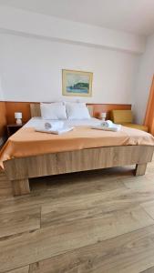 a large bed in a room with wooden floors at Hotel Molika in Magarevo