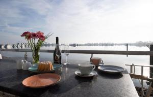 a table with a bottle of wine and a vase of flowers at Lillehuus in Olpenitz +13 photos