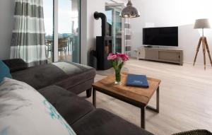 a living room with a couch and a table with flowers on it at Lillehuus in Olpenitz