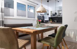 a kitchen and dining room with a wooden table and chairs at Lillehuus in Olpenitz