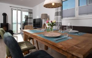 a dining room with a wooden table with flowers on it at Lillehuus in Olpenitz