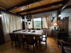 a dining room with a table and chairs and a window at A Hunter's Lodge in Dâmbovicioara