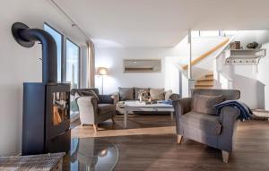 a living room with a fireplace and two chairs at Sommer Kajüte in Olpenitz