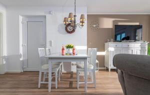 a dining room with a white table and chairs at Sommer Kajüte in Olpenitz