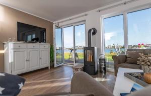 a living room with a fireplace and large windows at Sommer Kajüte in Olpenitz +16 photos