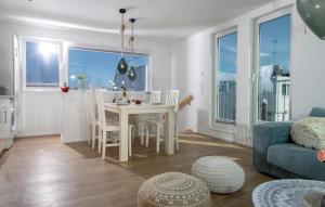 Una cocina y una sala de estar con mesa y sillas. en Sanibel, en Olpenitz