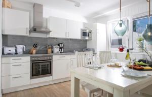 cocina con armarios blancos y mesa blanca en Sanibel, en Olpenitz 13 fotos más