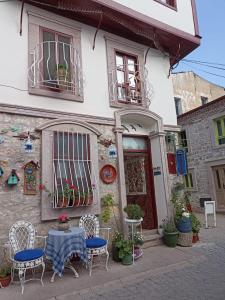 a table and chairs in front of a building at Chez Nebahat Boutique in Ayvalık