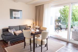 Una sala de estar con una mesa y sillas y un sofá. en Ferienappartement Hennen, en Konz