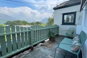 a balcony with two chairs and a fence at Snowdon Cottage in Llanberis