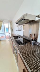 a kitchen with a sink and a stove top oven at Surf House Casa Vehla in Sal Rei