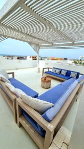 two beds under an umbrella on a patio at Surf House Casa Vehla in Sal Rei