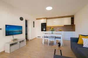 a living room with a couch and a table and a kitchen at Apartment Bokanjac Free Covered Parking & Quiet Neighborhood in Zadar