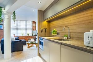 a kitchen with a sink and a living room at Cocoa Loft - parking included in York