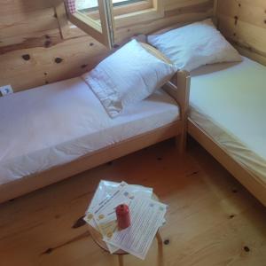 two bunk beds in a room with a book on the floor at Seoski Turizam Feniks apartman Davidovi Psalmi in Kosjeric