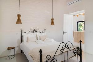Un dormitorio con una cama en blanco y negro y lámparas colgantes. en Monte Muro Country House, en Monsaraz