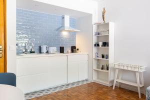 una cucina con armadietti bianchi e un muro di mattoni blu di Bela Vista in Almada Velha ad Almada Altre 20 foto