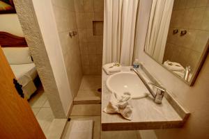 a small bathroom with a sink and a shower at Hotel Nacional in Oaxaca City