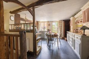 a kitchen with white cabinets and a table and chairs at Monk House - Historic Foundation Invites guests in Petworth +37 photos