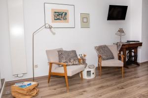sala de estar con 2 sillas y escritorio en Ferienappartement Hennen, en Konz