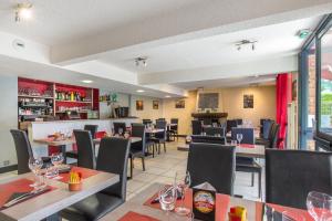 a dining room with tables and chairs and a restaurant at Brit Hotel Chambery in Chambéry