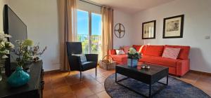 a living room with a red couch and a chair at Villa de Gracia Casa 2 in Tordera