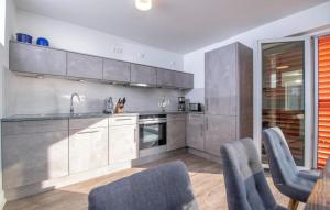 a kitchen with gray cabinets and blue chairs at B-Lodge in Olpenitz