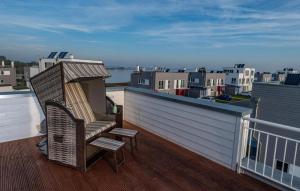 een stoel op een balkon met uitzicht op de stad bij Annas Heimat Am Meer in Olpenitz