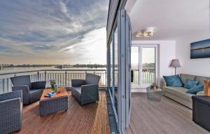een woonkamer met een bank en stoelen op een balkon bij Annas Heimat Am Meer in Olpenitz