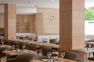 a restaurant with wooden tables and chairs with wine glasses at Hotel Las Vegas in Salou