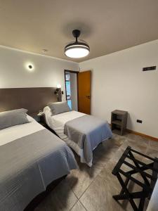 a bedroom with two beds and a light fixture at The View in Villa General Belgrano