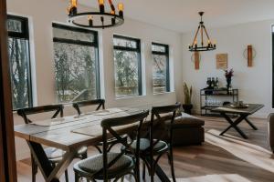 a dining room with a table and chairs and windows at Fellskotshestar Guesthouse in Selfoss