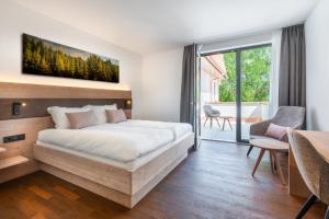 a bedroom with a large bed and a large window at Landhotel Grüner Wald in Neuhausen