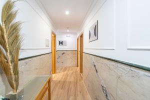 un pasillo con suelo de mármol y un jarrón en Hotel Las Américas, en Málaga 37 fotos más