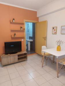 a living room with a tv and a table at Samos Cozy Apartment in Samos