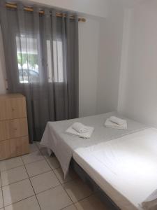 a bedroom with a bed with two towels on it at Samos Cozy Apartment in Samos