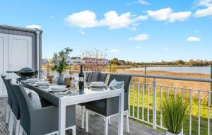 a white dining table on a balcony with a view of the water at Villa D'oro in Olpenitz
