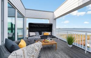 a patio with a couch and a table on a balcony at Villa D'oro in Olpenitz