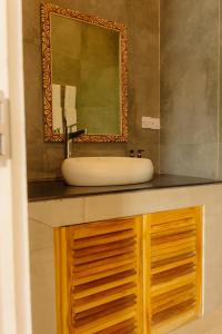 ein Badezimmer mit Waschbecken und Spiegel in der Unterkunft Heritage Sunset Retreat Zanzibar in Mchangani