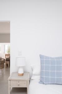 Un dormitorio con una cama y una mesa con una lámpara. en Lakeside Ocean Breeze, en Ciudad del Cabo