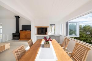 Un comedor con mesa y sillas de madera. en Lakeside Ocean Breeze, en Ciudad del Cabo