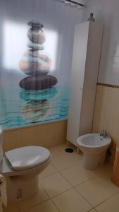 a bathroom with a toilet and a sink at La casita de Taty in Majanicho +7 photos