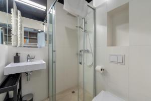 a bathroom with a glass shower and a sink at Apartamenty Książka do Poduszki - 250 metrów do Bulwarów Wiślanych - Dream Apart in Ustroń
