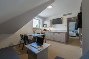 a kitchen and dining room with a laptop on a table at Apartamenty Książka do Poduszki - 250 metrów do Bulwarów Wiślanych - Dream Apart in Ustroń