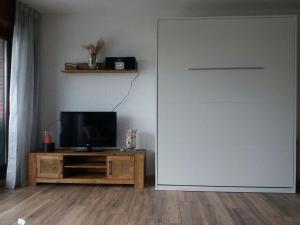 a living room with a television and a sliding door at Ferienwohnung Nordseetraum in Tossenserdeich