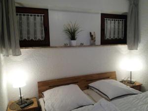a bedroom with a bed with two lamps on tables at Ferienwohnung Nordseetraum in Tossenserdeich +8 photos